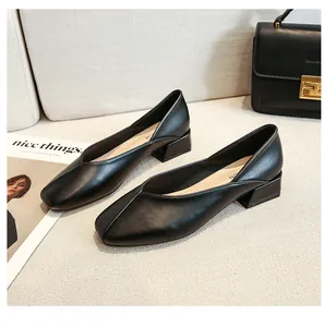 Detail view of black leather square toe loafers with elegant V-cut on light fabric