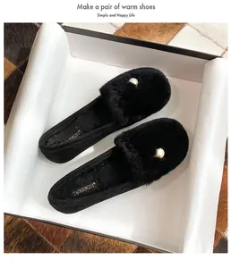 Detalle de mocasines de felpa negra con elegantes perlas y forro cálido de pelo sintético