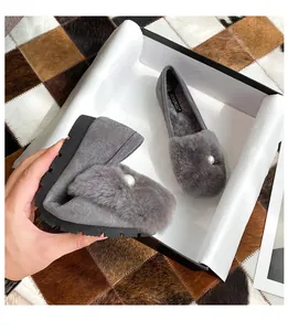 Primer plano de la suela de goma flexible y el forro de felpa de los zapatos grises de piel