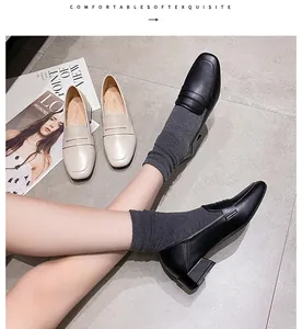 Nahaufnahme modischer Loafer mit Karree-Zehen und Blockabsatz in Schwarz und Beige