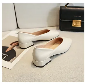 Macro shot of off-white square-toe chunky heel loafers with a matte leather texture