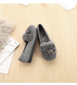 Detalle de mocasines de invierno grises con forro de felpa y hebilla de metal oro