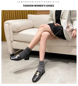 Detail of black loafers with large gold metal buckle and low block heel style
