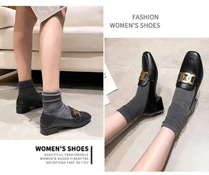 Close-up of black leather loafers with gold chain detail and comfortable low block heels