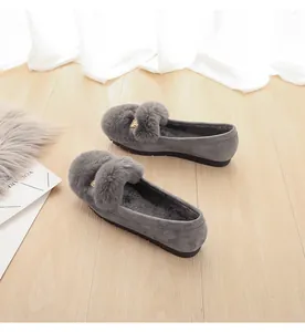 Detail van grijze suède loafers met warme pluche voering en metalen leeuwenkop gesp