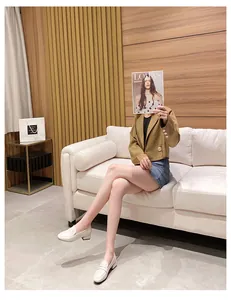 Cremeweiße Slipper kombiniert mit braunem Blazer und Jeansrock für einen schicken Look