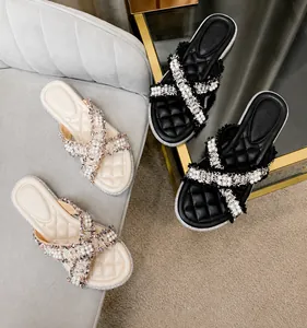 Dettaglio dei cinturini in tweed con perle e del plantare trapuntato di eleganti sandali bassi