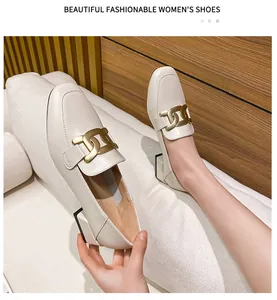 Detailed view of women's cream square-toe loafers with a stylish gold chain buckle accent