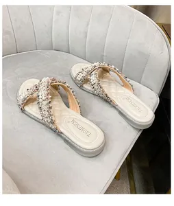 Dettaglio sandalo beige da donna con cinturini di perle e suola glitterata argento