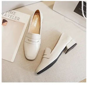 Nahaufnahme der beigen Loafer mit Blockabsatz auf minimalistischem Lifestyle-Hintergrund