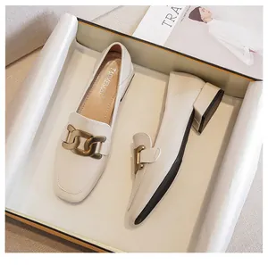 Detail view of retro square toe loafers in cream white with a chunky gold chain accent