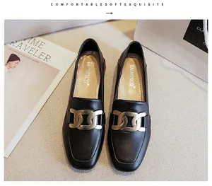 Close-up of black leather loafer with matte gold chain buckle and branded insole detail