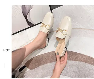 Detail of cream mule loafers featuring rhinestone horsebit buckle and sturdy mid-heel