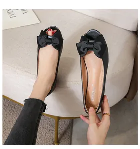 Nahaufnahme schwarzer Peeptoe-Ballerinas mit einer eleganten großen Satinschleife