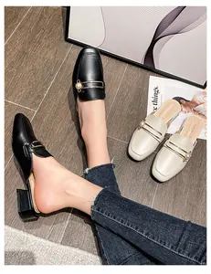 Detalle de mules de punta cuadrada con elegantes perlas y hebilla metálica decorativa