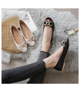 Detail of open-toe loafers featuring decorative gold chains in black and beige colors
