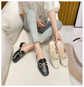 Detail of elegant mule loafers with rhinestone horsebit buckle and low block heels