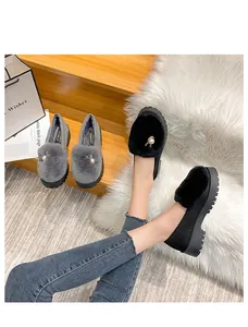 Détail de mocassins en peluche pour femmes avec bordure en fourrure et boucle en perle
