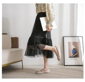 Beige flat peep-toe shoes with gold chain buckle shown on model in home setting