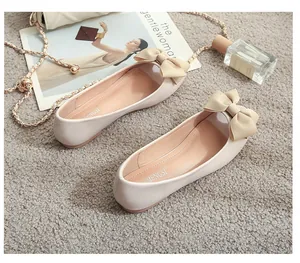 Detailaufnahme beiger flacher Ballerinas mit eleganter Schleife und weichem Mattenleder