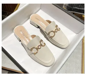 Macro detail of beige mule shoe featuring sparkling rhinestone metal horsebit buckle decoration
