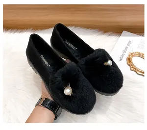 Détail de mocassins noirs en fourrure avec boucles en perles et semelles épaisses
