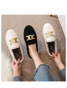 Close-up of fuzzy mule slippers featuring warm faux fur and a stylish gold metal chain
