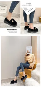 Detail view of black platform loafers featuring plush faux fur collar and pearl swan buckles