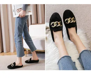Detail of black faux fur mule slippers featuring decorative gold chunky chain buckle