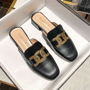 Schicke schwarze Damen-Mules mit klobigem niedrigem Absatz und großer mattgoldener Kette