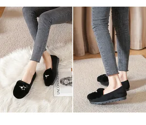 Detail van zwarte konijnenbont loafers met parel- en gouden steraccenten op een dikke zool