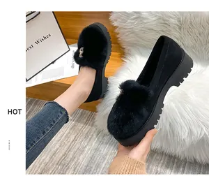 Detail of plush black loafers with thick rubber soles and rhinestone metal buckle accents