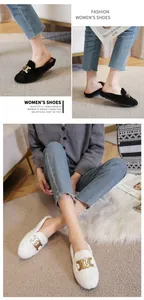 Close-up of plush flat mules with gold chain buckle in black and white options