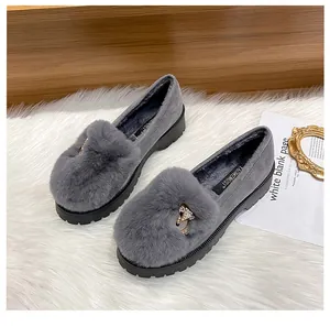 Detailed view of grey plush loafers with crystal fox buckle and thick rubber soles
