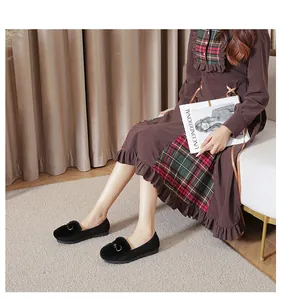 Detailed view of black faux fur loafers with silver metal buckle and soft rubber sole