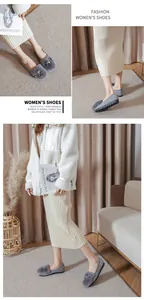 Detail van grijze suède loafers met konijnenbont pompon en parels in een gezellige setting