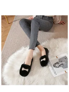 Gros plan de mocassins noirs en peluche avec nœud en perles et doublure en fausse fourrure