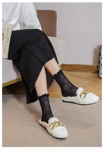 Detail of white plush slippers with gold chain accent and lace socks for a cozy lifestyle