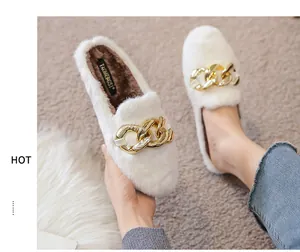 Detail of white faux fur mule with gold chain buckle on cozy grey carpet background