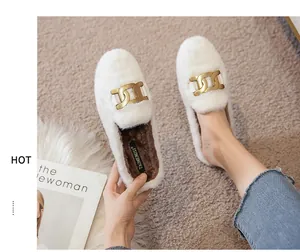Close-up of white plush loafers with gold chain detail and warm faux fur lining