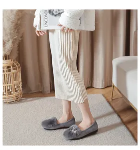 Detail van grijze damesloafers met imitatiebont en elegante parels voor een luxe uitstraling
