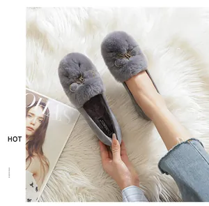 Detail of grey faux fur loafers featuring a sparkling rhinestone bow buckle and soft lining