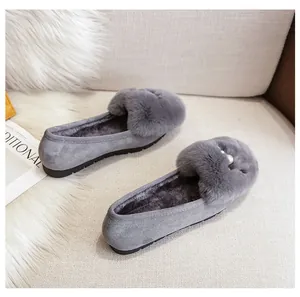 Detail van grijze harige loafers met parels en antislipzolen voor de wintermaanden