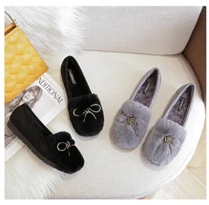 Detail of plush faux fur loafers with gold chain bows and warm fleece lining for women