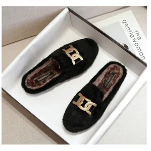 Detail of black faux fur mule slippers with chunky gold metal chain and warm lining