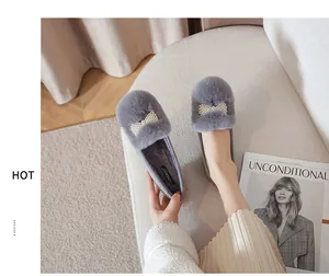 Détail de mocassins en peluche grise avec un élégant nœud en perles sur le dessus
