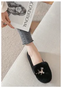 Detail van zwarte loafers van imitatiebont met luxe uilgesp voorzien van strassteentjes