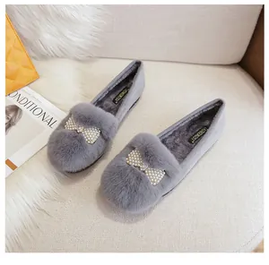 Détail de mocassins en fausse fourrure grise avec nœud en perles et doublure chaude