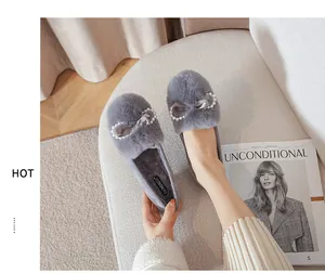 Dettaglio di pantofole in peluche grigio con fiocco di raso e perle sintetiche