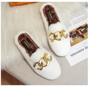 Detailed top view of white faux fur mule slippers with gold chain and plush brown lining